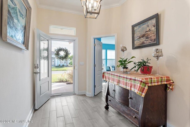 foyer entrance with plenty of natural light, an inviting chandelier, ornamental molding, and light hardwood / wood-style flooring