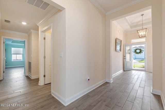 entryway featuring crown molding, wood-type flooring, and a notable chandelier