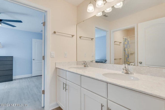 bathroom with wood-type flooring, vanity, ceiling fan, and curtained shower