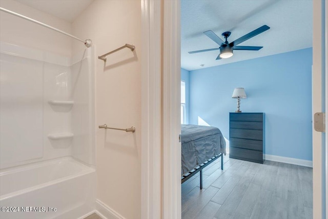 bathroom featuring ceiling fan, tub / shower combination, and hardwood / wood-style flooring