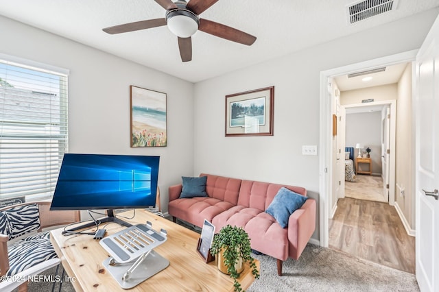 living room featuring hardwood / wood-style floors and ceiling fan