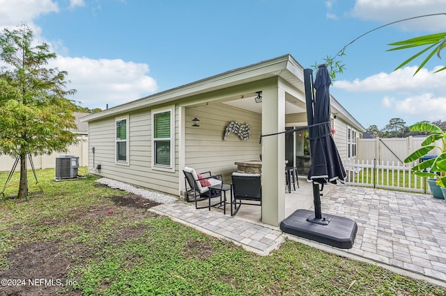 rear view of house with central AC and a patio area