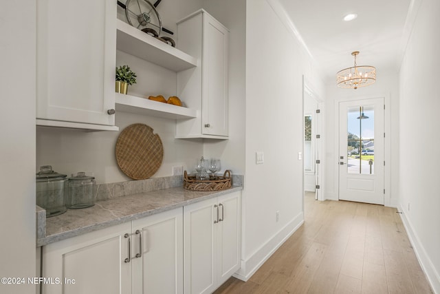 bar with pendant lighting, light wood finished floors, recessed lighting, a chandelier, and baseboards