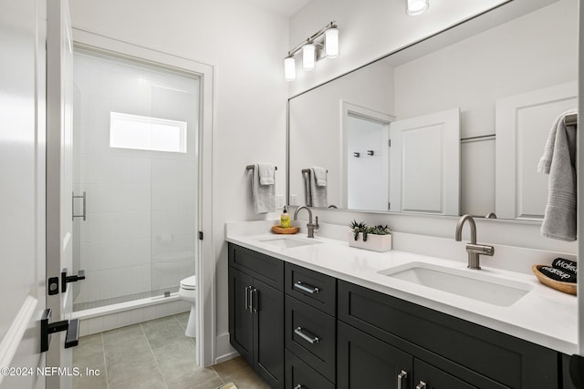 full bath featuring double vanity, a stall shower, a sink, and toilet