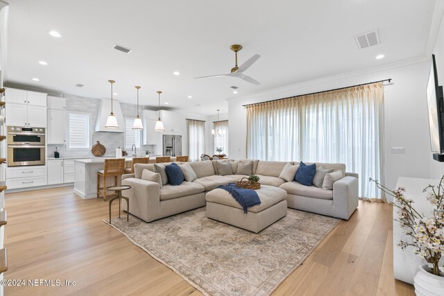 living area with a healthy amount of sunlight, visible vents, and light wood finished floors