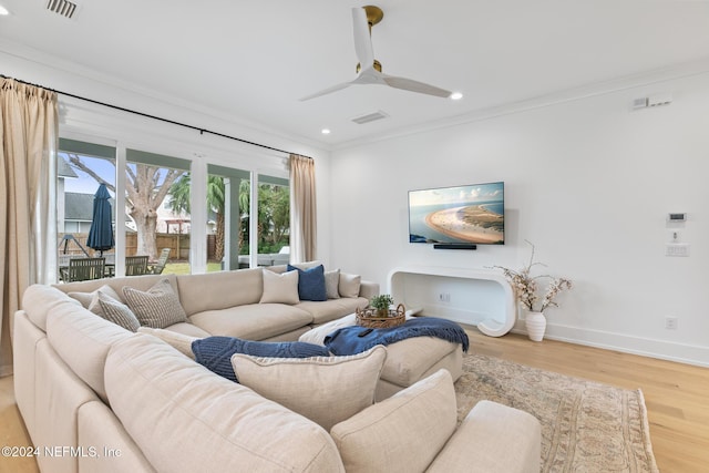 living room featuring baseboards, visible vents, and crown molding