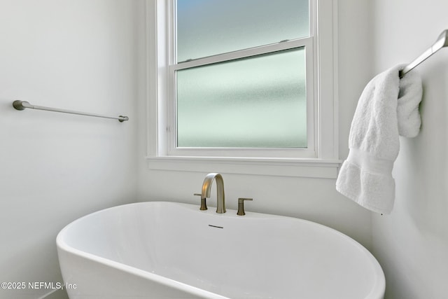 full bath featuring a soaking tub and a sink