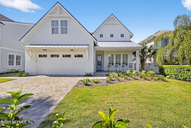 55A Solana Rd, Ponte Vedra Beach, FL 32082 - view of front of home with a porch, decorative driveway, a front yard, an attached garage, and a metal roof