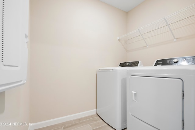 clothes washing area featuring light hardwood / wood-style flooring and washing machine and dryer