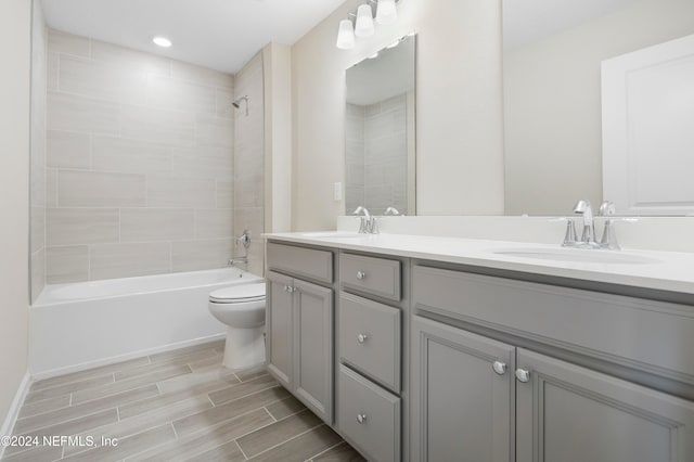 full bathroom featuring toilet, tiled shower / bath combo, and vanity