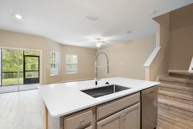 kitchen featuring a center island with sink, sink, ceiling fan, light hardwood / wood-style flooring, and dishwasher