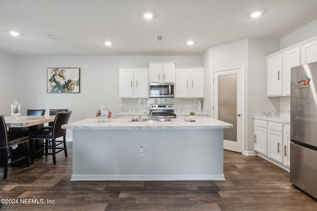 kitchen with a center island with sink, white cabinets, dark hardwood / wood-style floors, and appliances with stainless steel finishes