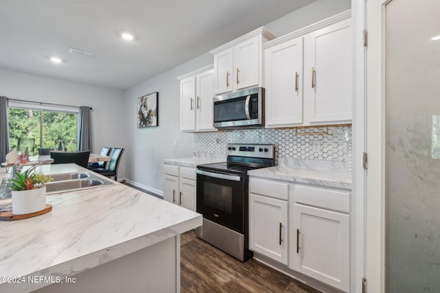 kitchen with sink, tasteful backsplash, dark hardwood / wood-style flooring, white cabinetry, and stainless steel appliances