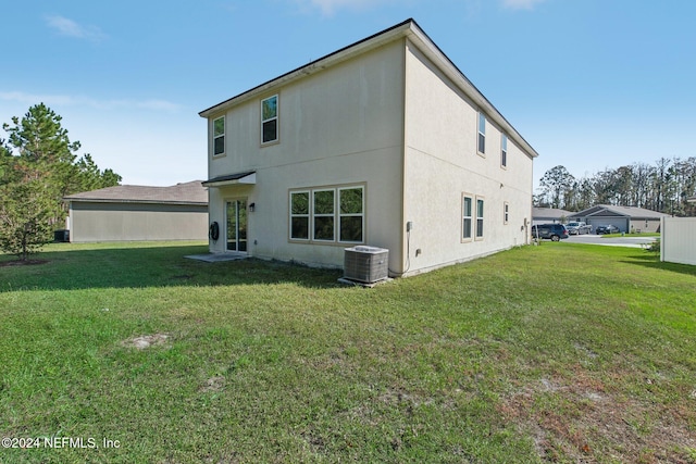 back of property featuring a yard and central AC