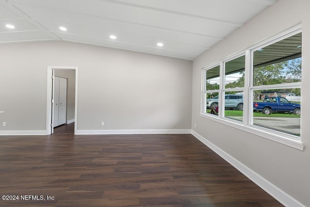 spare room featuring dark hardwood / wood-style flooring and vaulted ceiling