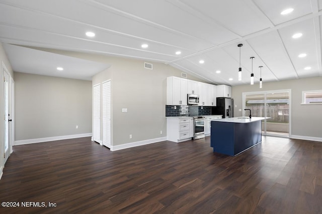 kitchen with appliances with stainless steel finishes, dark hardwood / wood-style floors, a kitchen island with sink, and pendant lighting