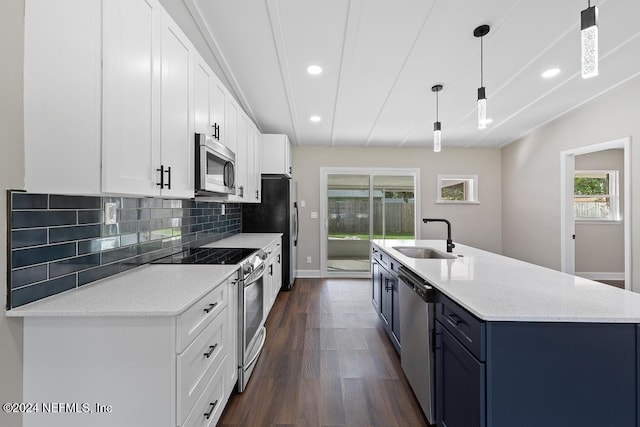 kitchen featuring pendant lighting, white cabinets, sink, dark hardwood / wood-style flooring, and stainless steel appliances