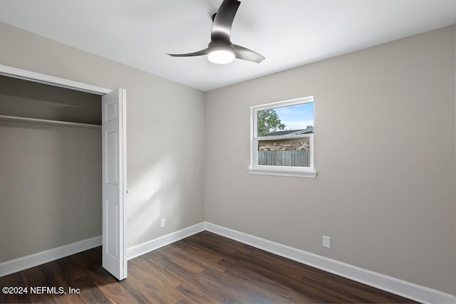 unfurnished bedroom featuring ceiling fan, dark hardwood / wood-style flooring, and a closet