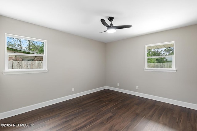 empty room featuring a wealth of natural light, dark hardwood / wood-style flooring, and ceiling fan