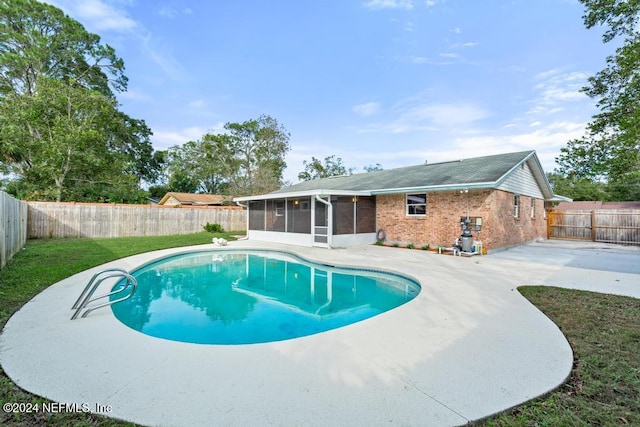 view of pool featuring a patio area, a sunroom, and a yard