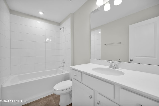 full bathroom featuring toilet, vanity, tiled shower / bath, and tile patterned floors