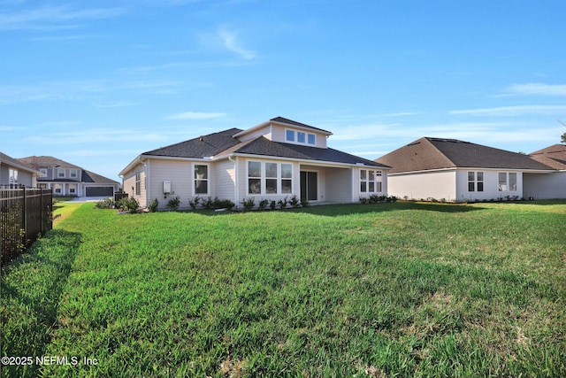 back of property featuring fence and a yard