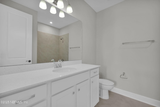 bathroom featuring toilet, vanity, baseboards, a tile shower, and tile patterned floors