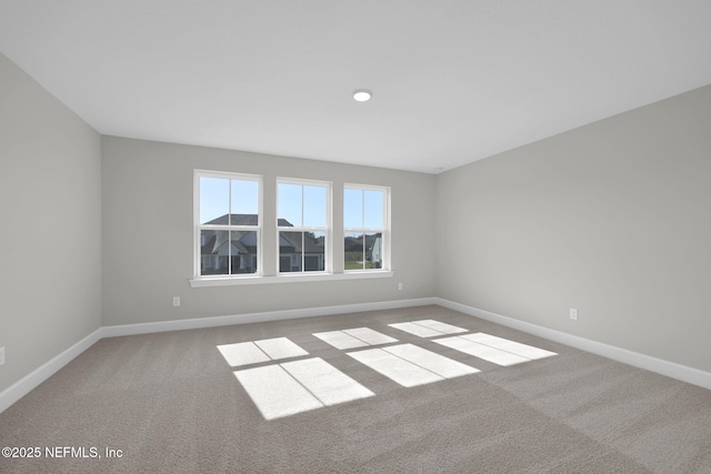 unfurnished room featuring carpet floors and baseboards