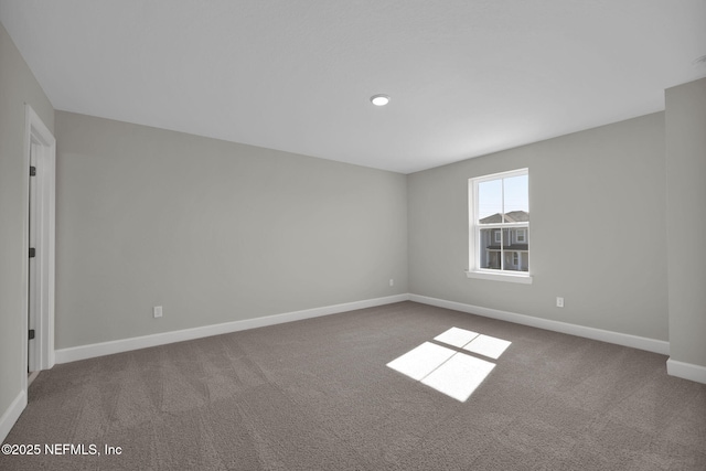 empty room featuring carpet floors and baseboards