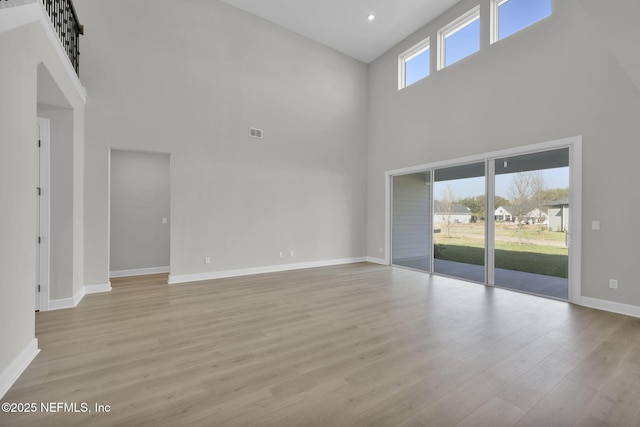 unfurnished living room with light wood finished floors, recessed lighting, visible vents, and baseboards