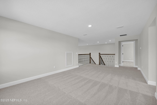 unfurnished room featuring carpet floors, recessed lighting, visible vents, a textured ceiling, and baseboards