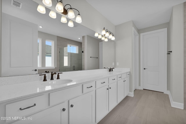 bathroom with double vanity, a sink, visible vents, and a shower stall