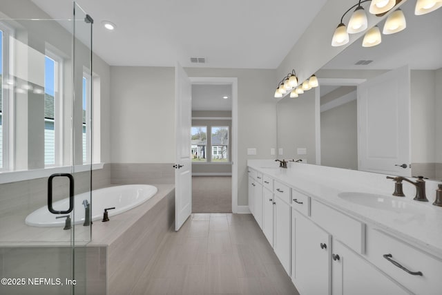 full bath featuring double vanity, visible vents, a sink, and a bath