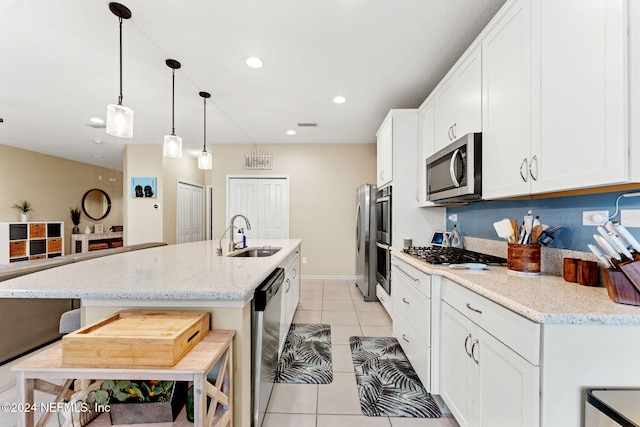 kitchen featuring white cabinetry, appliances with stainless steel finishes, sink, and light stone countertops