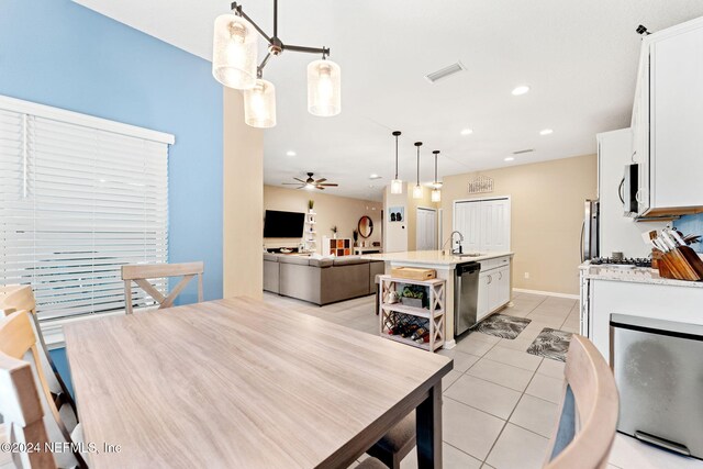 tiled dining area featuring ceiling fan and sink