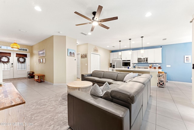 tiled living room featuring ceiling fan and french doors