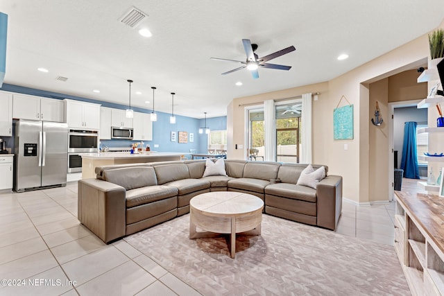 tiled living room with ceiling fan and a textured ceiling