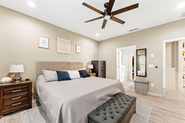 bedroom with ensuite bath, light hardwood / wood-style floors, and ceiling fan