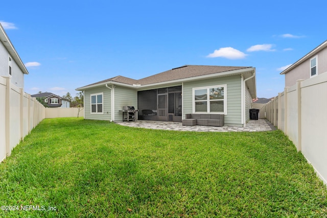 rear view of property featuring a lawn and a patio