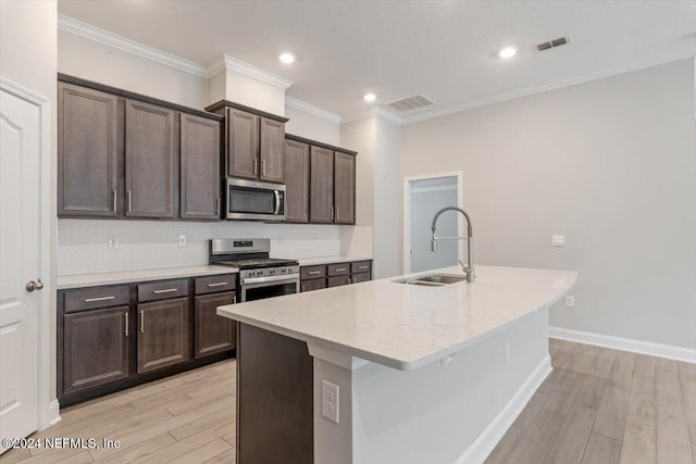 kitchen featuring stainless steel appliances, sink, an island with sink, crown molding, and light hardwood / wood-style flooring