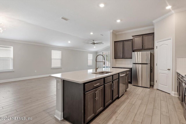 kitchen featuring light hardwood / wood-style floors, sink, an island with sink, ceiling fan, and appliances with stainless steel finishes