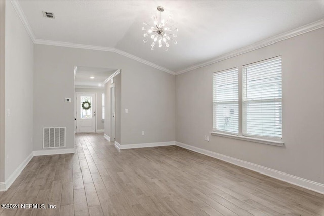 empty room featuring ornamental molding, light wood-type flooring, and a notable chandelier