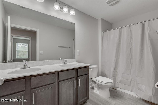 bathroom with hardwood / wood-style flooring, vanity, and toilet