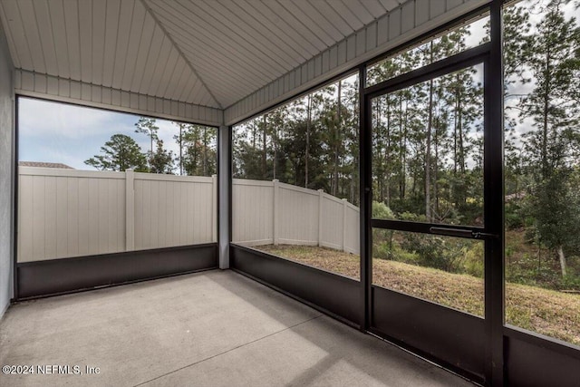 unfurnished sunroom with wood ceiling, vaulted ceiling, and a healthy amount of sunlight