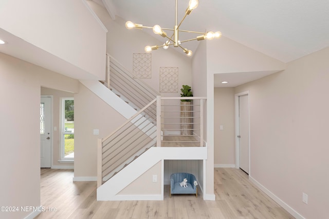 stairway featuring high vaulted ceiling, a chandelier, and hardwood / wood-style flooring