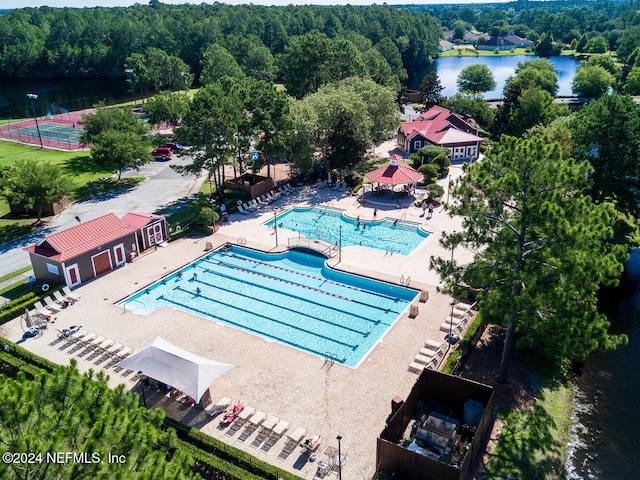 view of swimming pool featuring a water view and a patio area