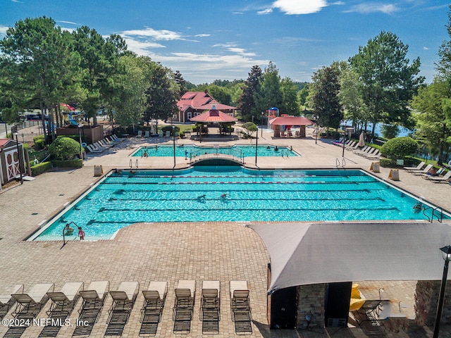 view of swimming pool featuring a hot tub and a patio area