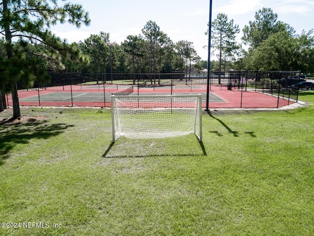 view of sport court with a yard