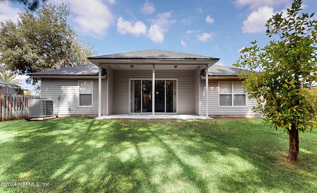 back of property with central air condition unit, a lawn, and a patio