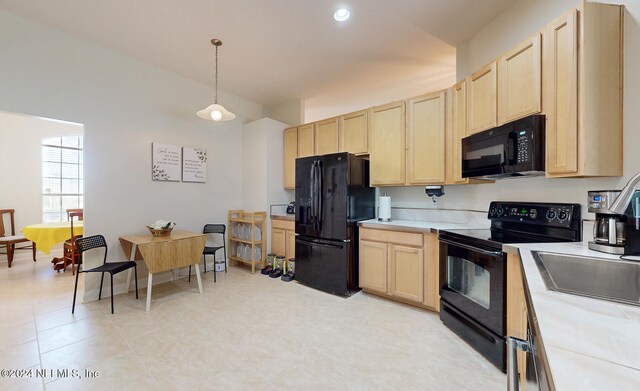 kitchen featuring black appliances, light brown cabinetry, and decorative light fixtures